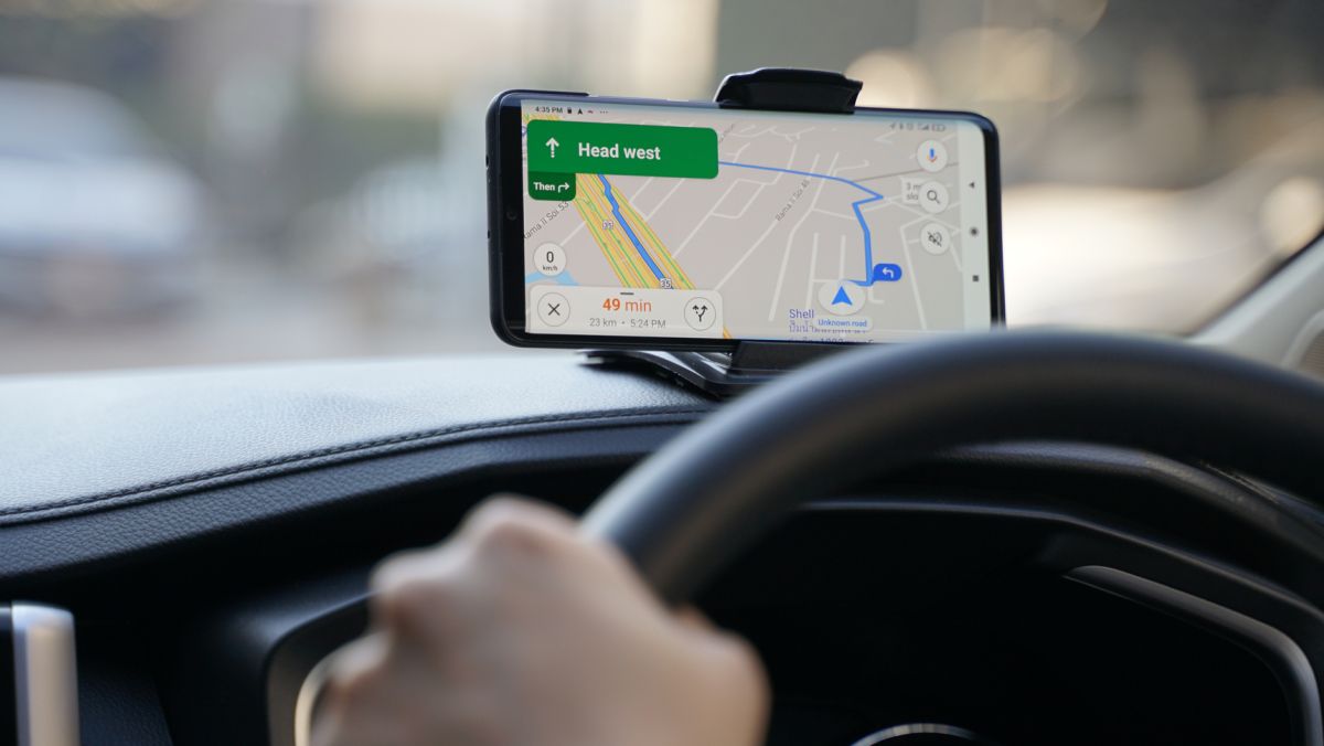 Close up of man Driving a car and holding smartphone using application Google Maps to destination