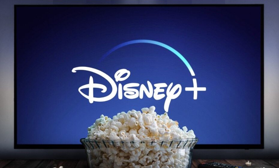 Giant bowl of popcorn in front of TV screen with Disney+ logo displayed