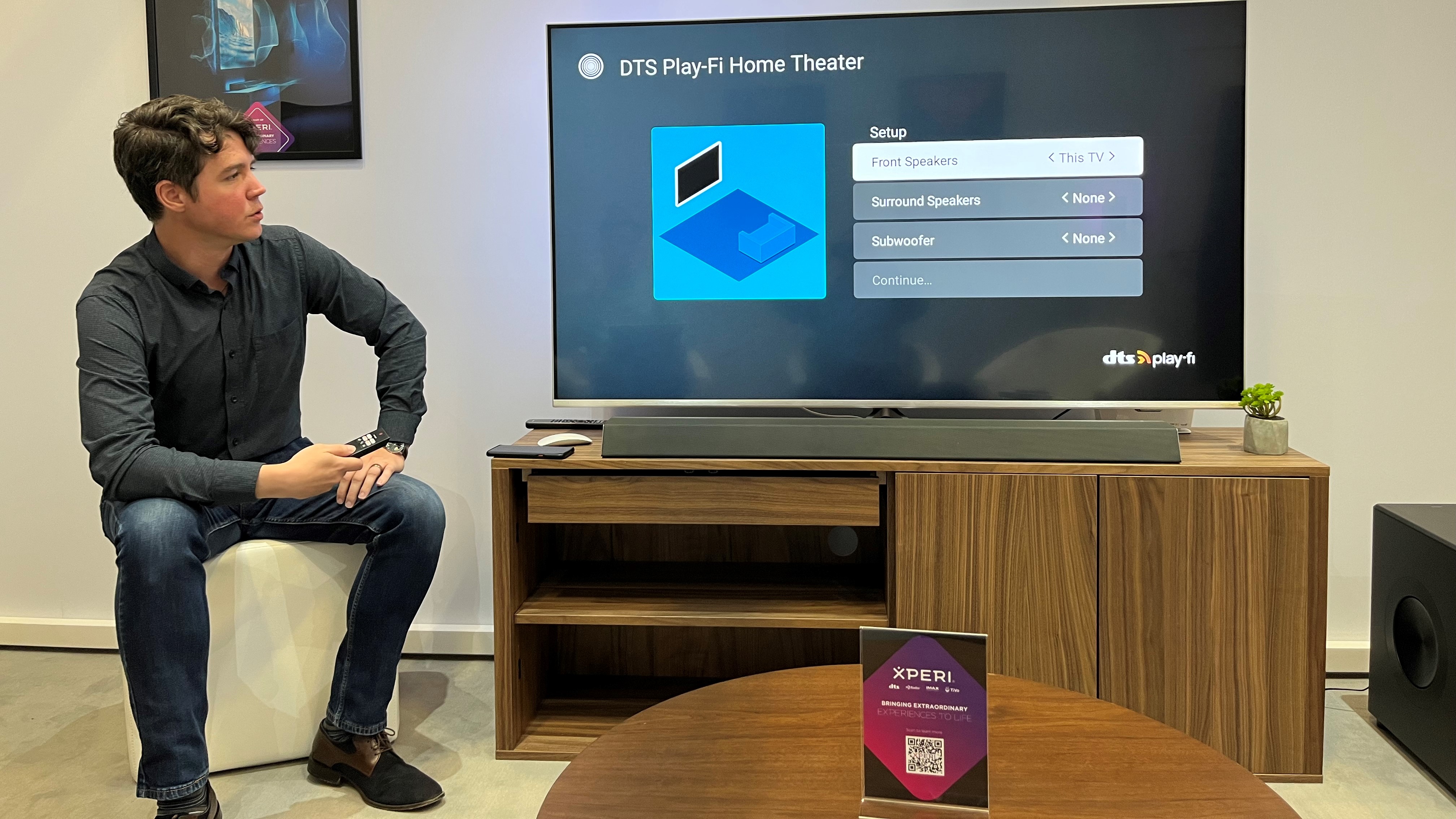 DTS Play-Fi demonstration on TV with product manager nearby