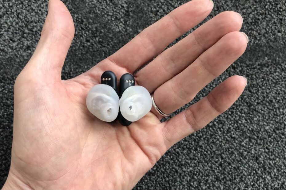 UE Fits earbuds in a hand on white background