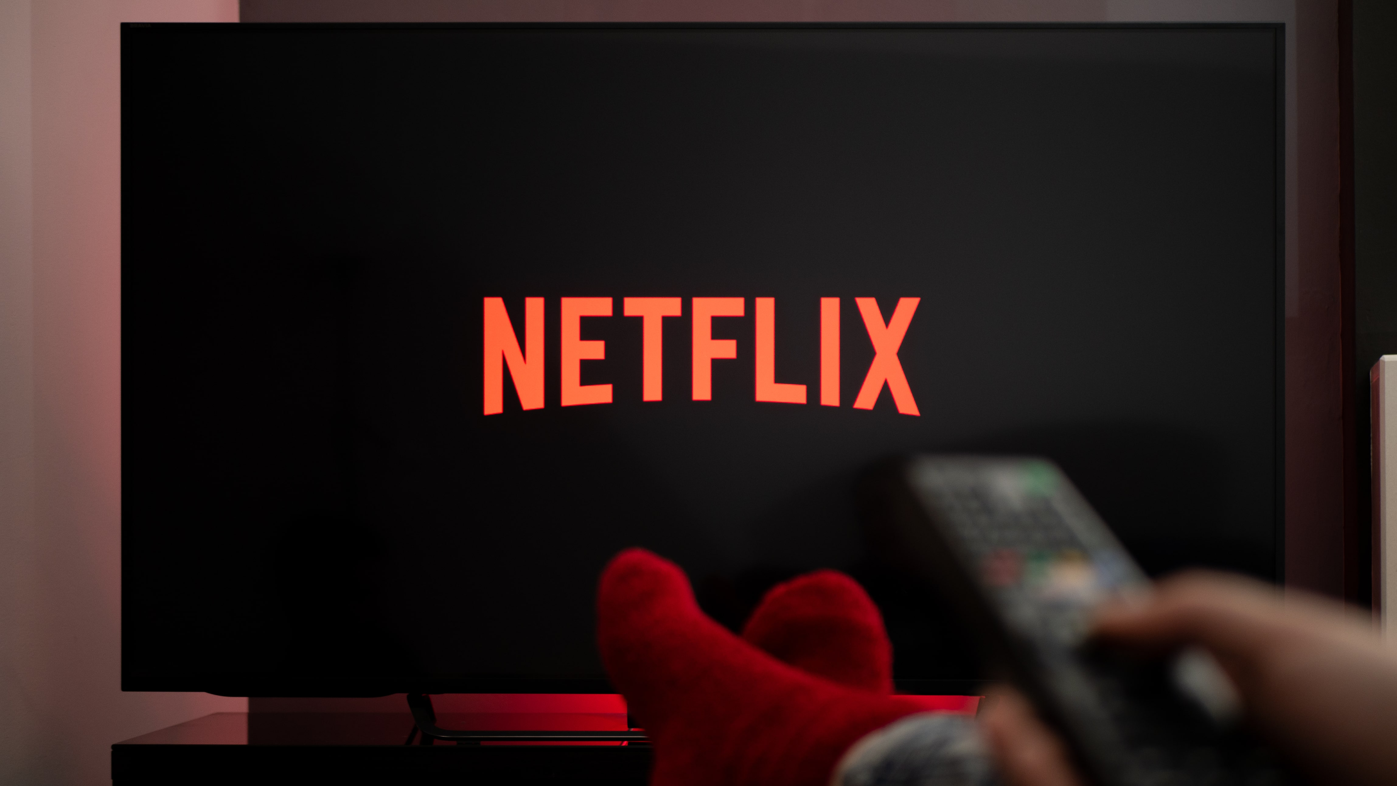 Man with his feet up on a table while watching Netflix on TV