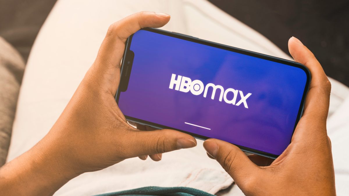 A person holds a smartphone with the HBO Max logo on it